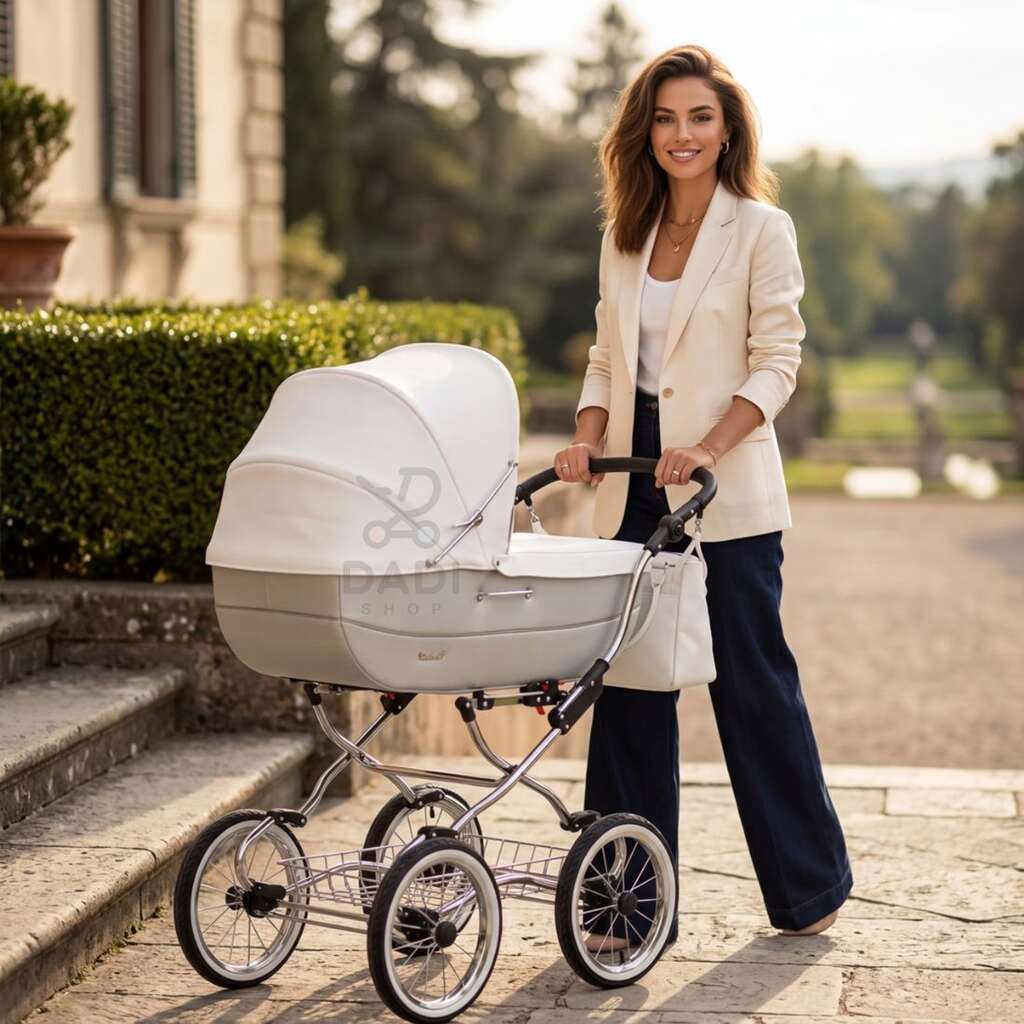 Elegancka mama z biało-szarym wózkiem retro Baby Fashion Renee R-2 na tle klasycznego ogrodu.