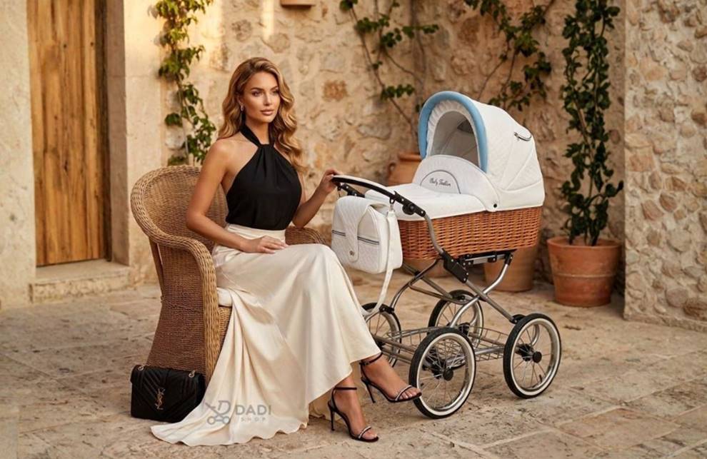 Elegancka kobieta w letniej stylizacji siedząca obok klasycznego wózka dziecięcego Scarlett w stylu retro na tarasie w słonecznym klimacie