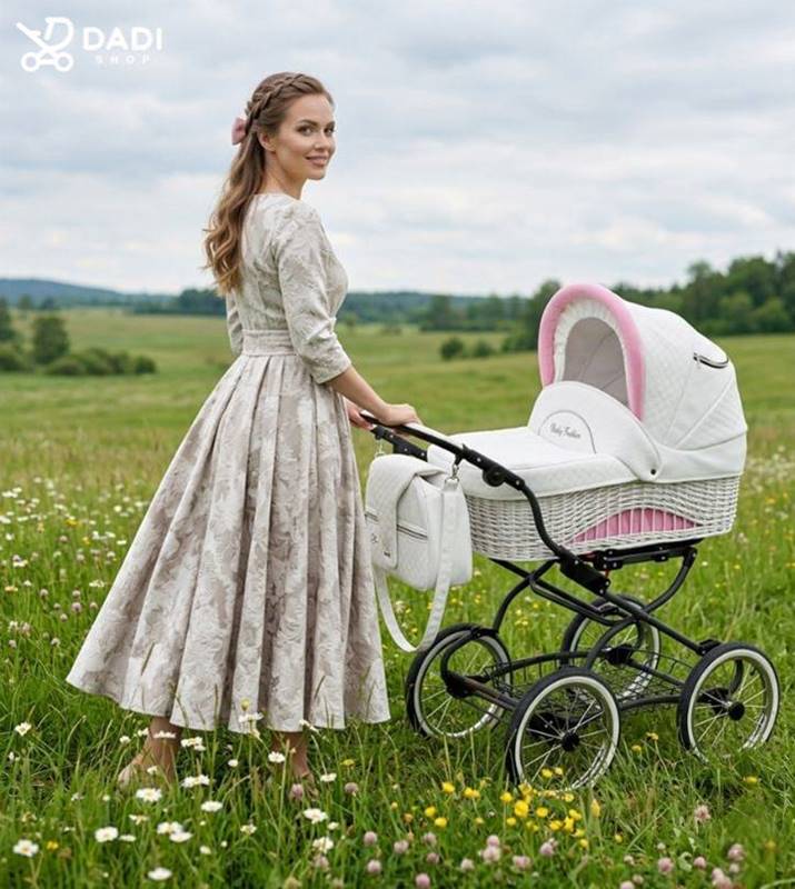 Mama spaceruje z niemowlakiem w wózku Scarlett retro stylistyka różowymi akcentami na tle zielonej łąki pełnej kwiatów