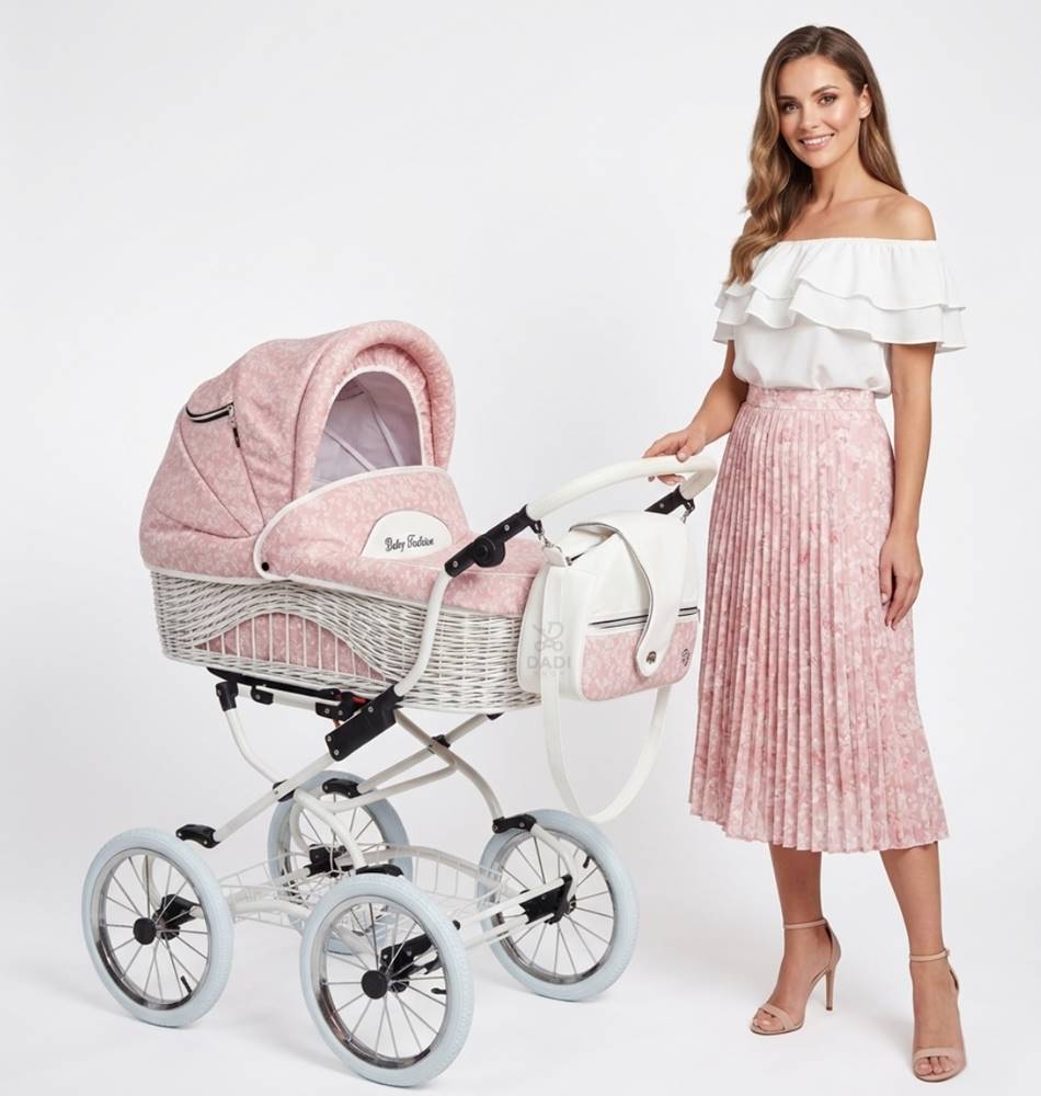 Wielofunkcyjny wózek dziecięcy w stylu retro w różowo-białe kwiatki z wiklinową gondolą, białą ramą i pasującą torbą, zaprezentowany w studiu z modelką