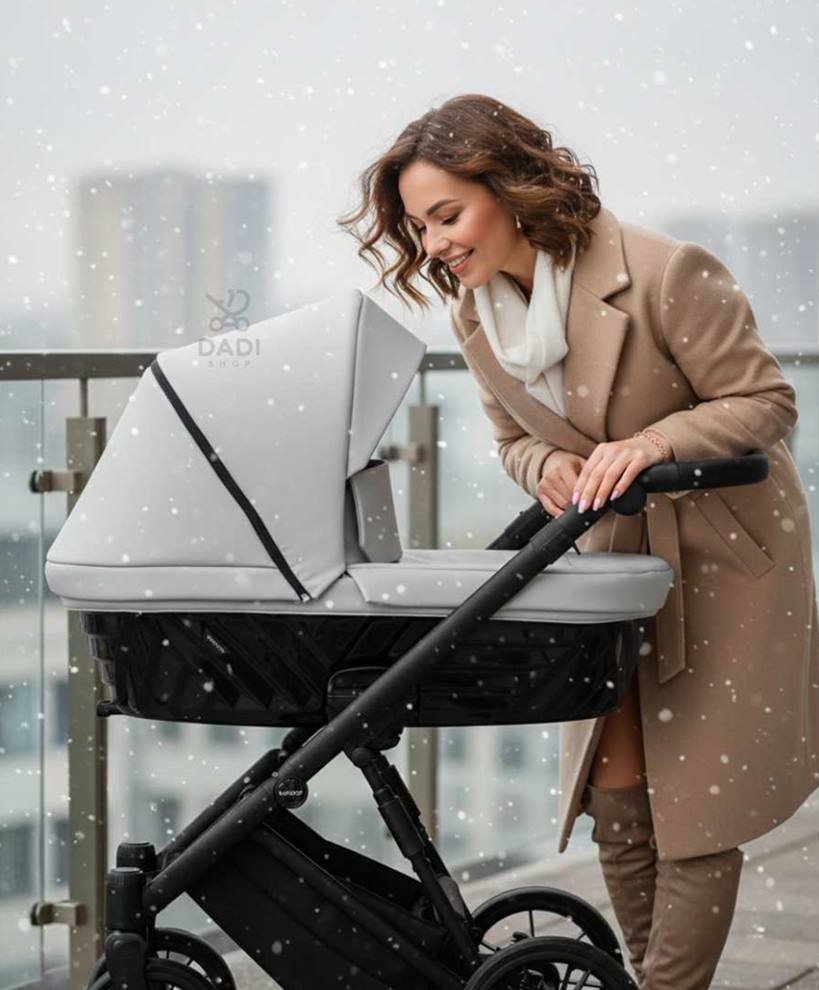 Kobieta z wózkiem Kunert Ivento podczas werandowania dziecka zimą, delikatny śnieg, Dadi-Shop
