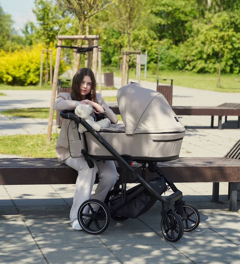 Wózek Coletto Flow 2w1 w kolorze chłodnego beżu, idealny na słoneczny dzień – elegancka gondola i spacerówka w jednym, zapewniające komfort maluszkowi.