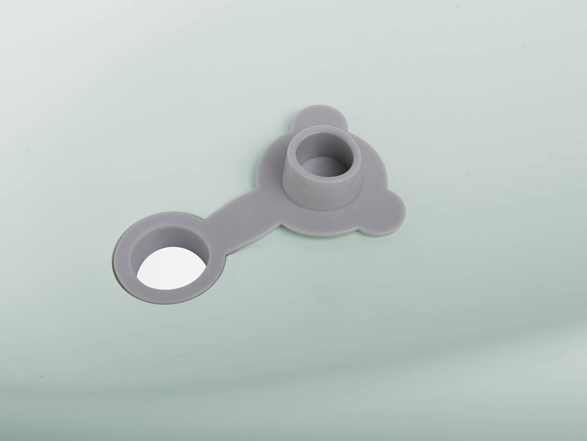 Otwarty szary gumowy zawór odpływowy zamontowany w dnie wanienki Colibro Spa 2w1.