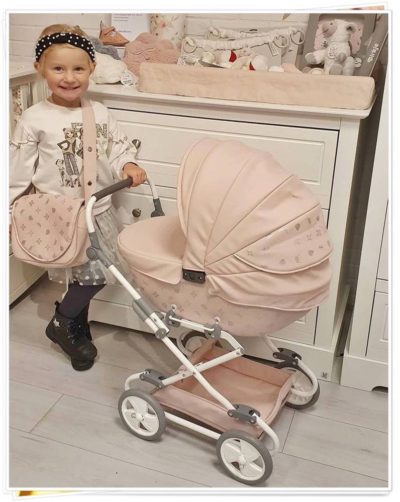 Dziewczynka bawi się różowym wózkiem dla lalek Tako Imperial Mini – jasny kolor z eco skóry, elegancki i funkcjonalny, Dadi-Shop