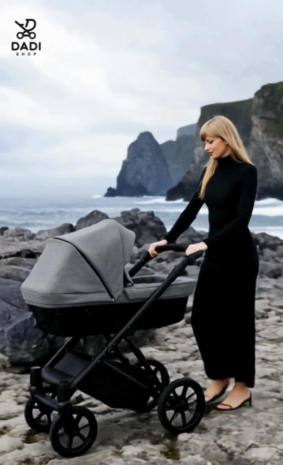 Wózek Kunert Ivento 09 w kolorze Deep Graphite na tle morskich klifów, z naturą w tle – elegancka mama prowadzi wózek, symbolizując harmonię macierzyństwa i natury.