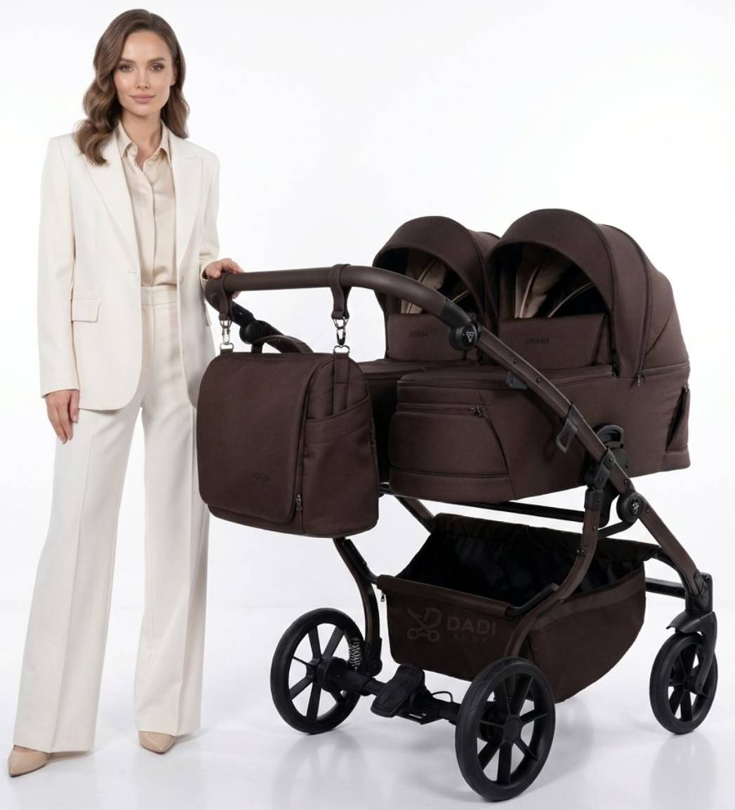 Elegancka prezentacja brązowego wózka podwójnego Junama Duo V4 z dwiema gondolami i torbą pielęgnacyjną, obok stoi kobieta.