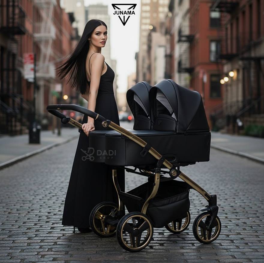 Wielofunkcyjny wózek bliźniaczy Junama Duo V3 Eco Black & Gold – stylowa mama spaceruje po miejskim tle. dadi-shop on line