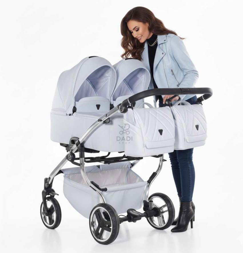 Modelka nachyla się nad dwoma gondolami w wózku bliźniaczym duo V3 od JUNAMA.