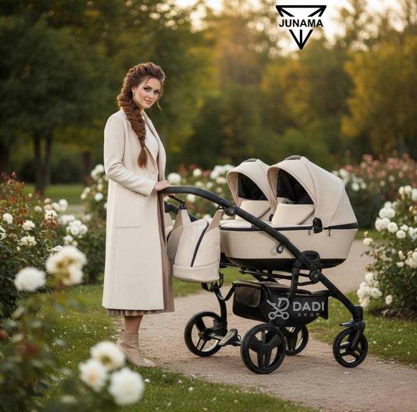 Elegancka kobieta w płaszczu spacerująca w plenerze z wózkiem bliźniaczym Junama Space Duo Eco 02 Latte.