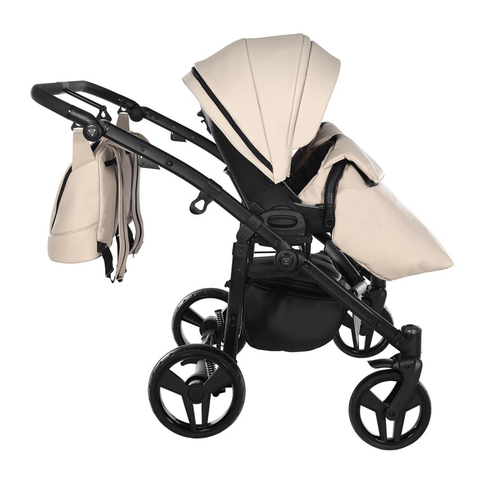 Junama Space Duo Eco ustawiony bokiem z przykryciem na nóżki dziecka, kolor beige.