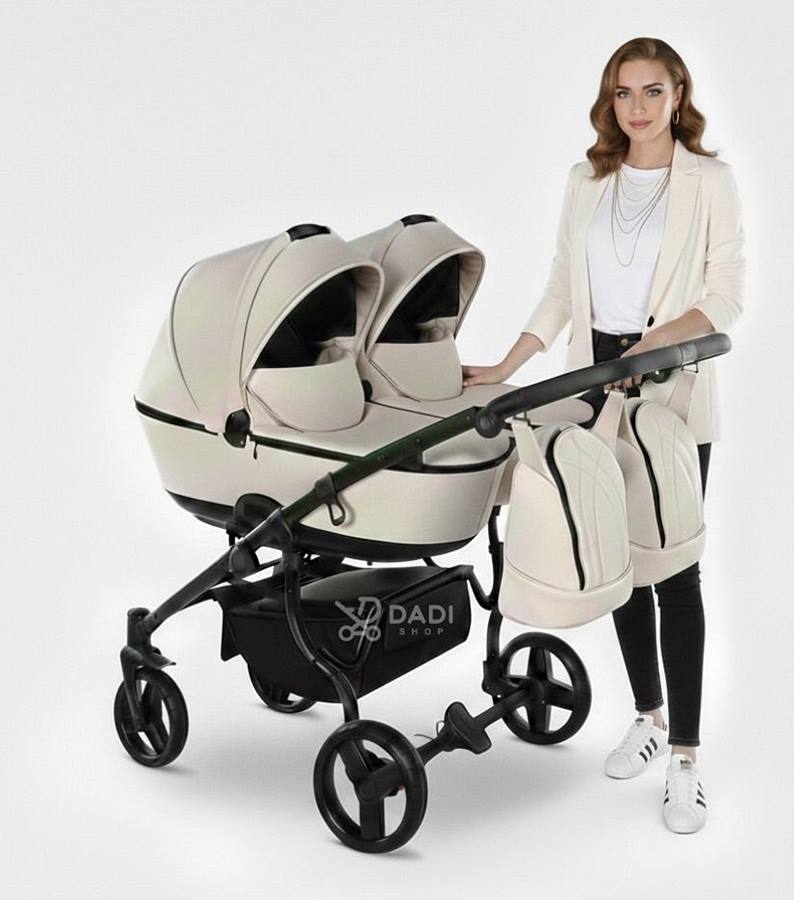 Wózek dla dwójki dzieci Junama Duo Space Eco w jasnym ecru/kremowym kolorze z dwiema gondolami, prezentowany przez kobietę.
