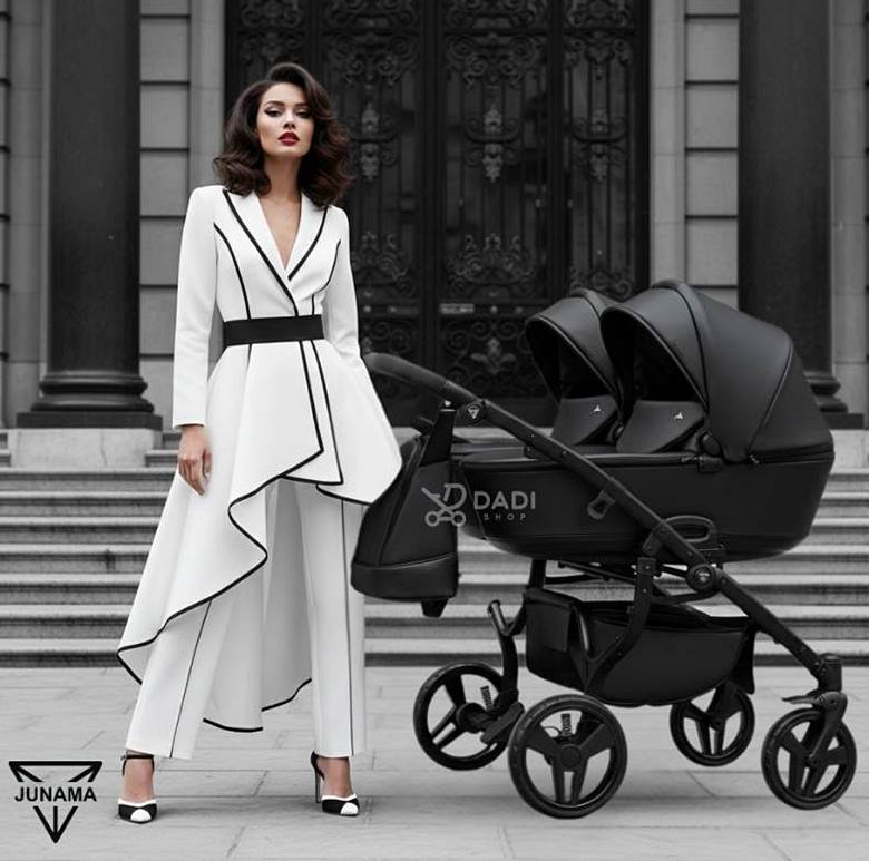 Stylowa mama z wózkiem bliźniaczym Junama Space Duo 3w1 czarny na tle kamienicy,