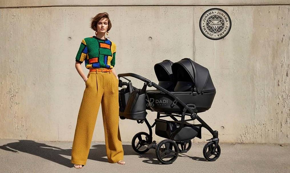 Junama Space Duo Black – wózek dla bliźniąt z gondolami obok siebie w sesji modowej.