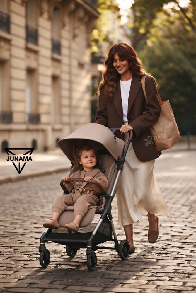 Stylowa mama na spacerze z maluchem w nowoczesnej spacerówce Junama Aviator w miejskiej scenerii.