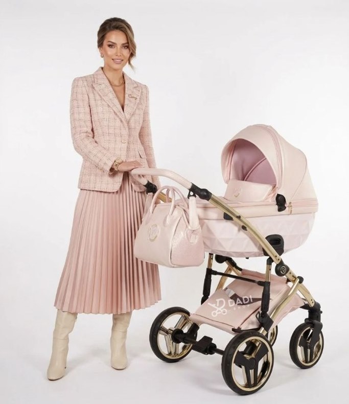 Wózek Junama Candy Premium 01 Pearl w jasnym perłowym różu z gondolą – zdjęcie studyjne z modelką.