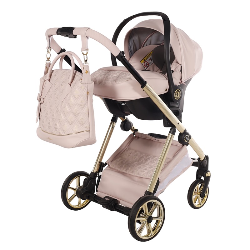 Różowy fotelik samochodowy Junama Ellegante zamontowany na złotym stelażu wózka z torbą pielęgnacyjną.