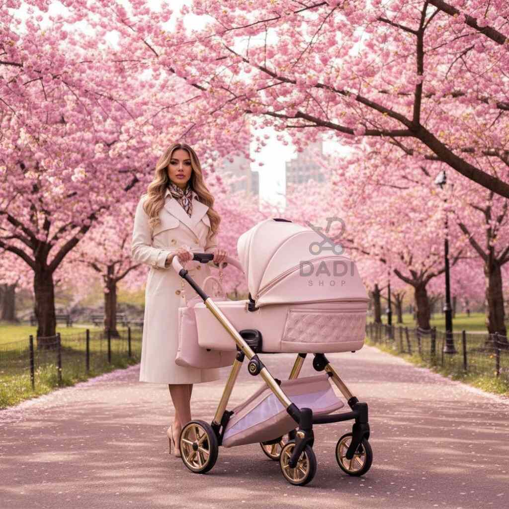 Kobieta w jasnym płaszczu z różowym wózkiem Junama Ellegante Art Deco 01 Pink na tle kwitnących różowych drzew w parku.