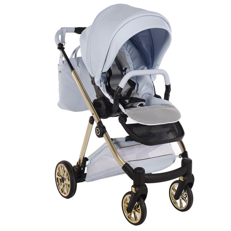 Błękitna spacerówka Junama Ellegante Art Deco 03 Blue na złotym stelażu. Widoczne pasy bezpieczeństwa, barierka i pasująca torba w zestawie.