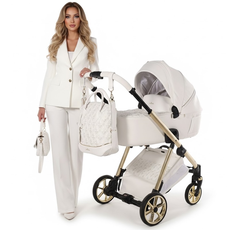 Elegancka kobieta w białym garniturze stoi obok wózka Junama Ellegante Art Deco 04 White na złotym stelażu z dopasowaną torbą pielęgnacyjną.