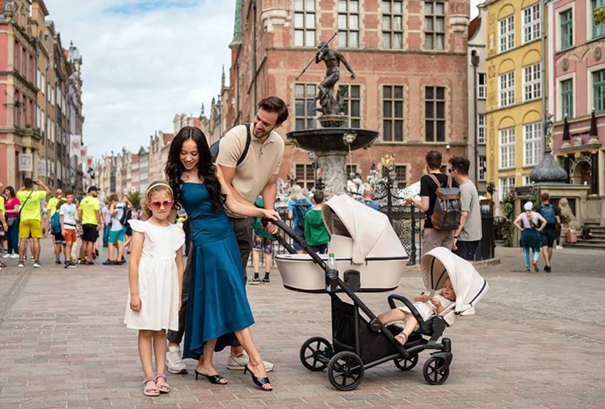 Rodzina z dwójką dzieci i wózkiem Brav Duo spaceruje po gdańskiej Starówce przy Fontannie Neptuna.