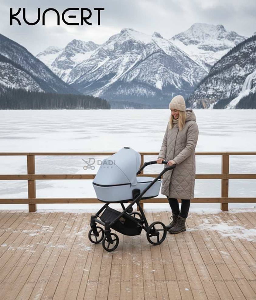 Wózek wielofunkcyjny Kunert Brav na tarasie zimą, góry w tle, modelka prezentuje amortyzowaną konstrukcję.