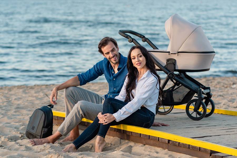 rodzice odpoczywają na plaży z wózkiem kunert brav 3w1