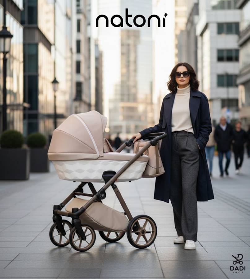 Modne zdjęcie street style: kobieta w granatowym płaszczu i okularach przeciwsłonecznych, prowadząca nowoczesny wózek Natoni Baby Abis w kolorze beżowym na tle szklanych wieżowców. Scena podkreśla elegancję i miejski styl.