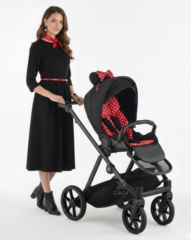 Wózek spacerowy Natoni Joy New z motywem uszek myszki, sesja studyjna z modelką, czarny w kropki, przekładane siedzisko przód tył.