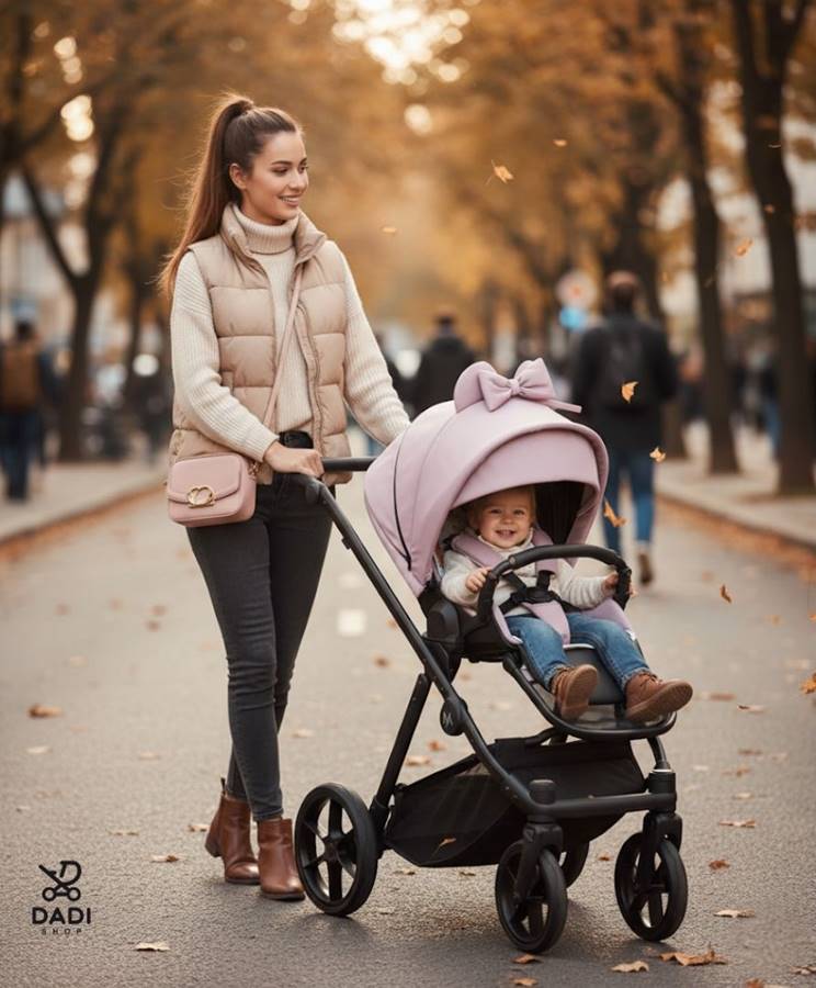 Zdjęcie przedstawia młodą matkę w jesiennej stylizacji (puchowy bezrękawnik) spacerującą po miejskiej ulicy z uśmiechniętą córeczką w różowym wózku spacerowym Natoni Joy. New- sklep dadi-shop