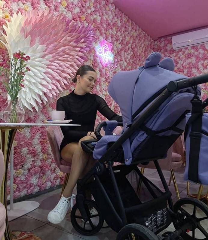 Wózek spacerowy Natoni Joy New Veri Peri jasny wrzos widok z tyłu w nowoczesnej kawiarni, ujęcie lifestyle