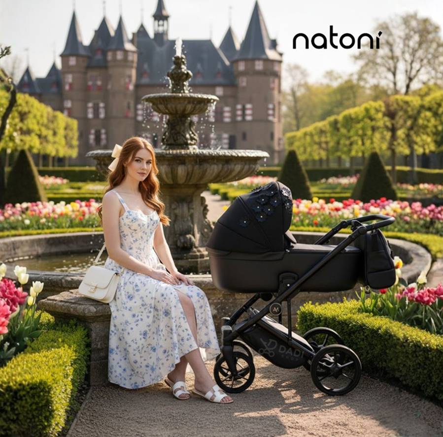 Kobieta siedzi na ławce w parku przy fontannie – obok wózek  4w1 Vespa Blossom Licorice czarny i stylowy.