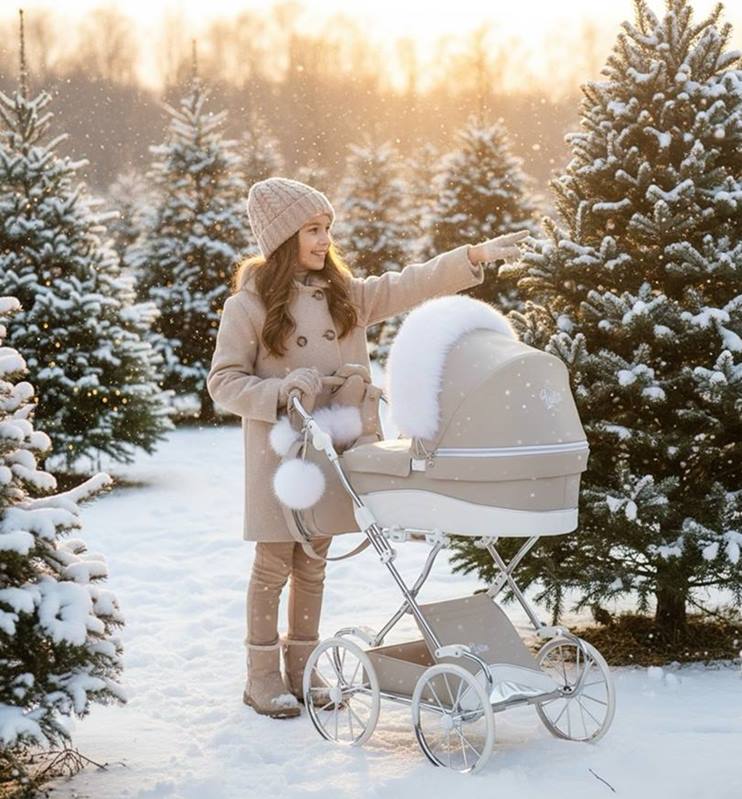 Sceneria zimowa, dziewczynka szczęśliwa bawi się wózkiem dla lalek Lulla Junama z pomponem na rączce wózka.