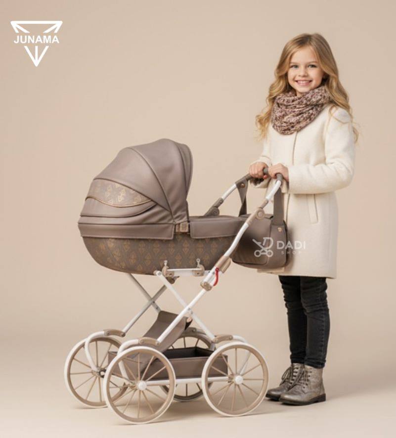 Tako Baby Junama Art Deco Mini – brązowy wózek dla lalek z dużymi kołami, wyglądający jak prawdziwy, prezentowany przez dziewczynkę. dadi-shop