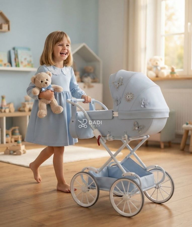 Mała opiekunka z misiem bawi się wózkiem Junama Mini Fleur o regulowanej rączce w jasnym pokoju dziecięcym.