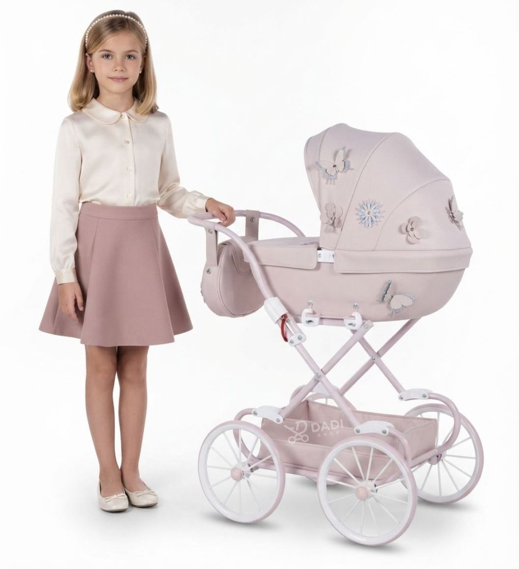 Pink Junama La Fleur Mini doll pram in retro style with large spoked wheels and decorative butterfly appliques.
