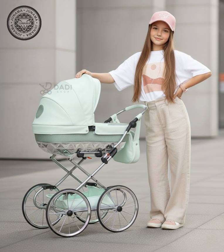 Wózek dla lalek Junama Handcraft Mini w kolorze miętowym, prezentowany przez dziewczynkę w plenerze miejskim.