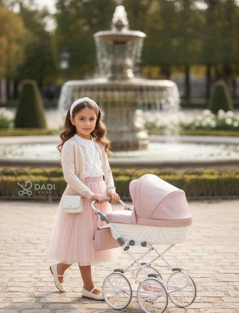 Girl with pink dolls pram Kunert Rossie during a spring walk in the park. Dadi-shop