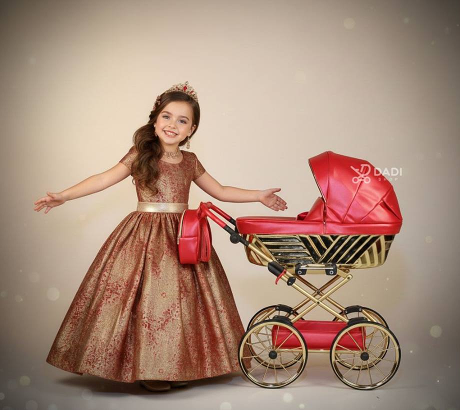 Wózek dla lalek Royal. Dziewczynka pokazuje wózek, poza dynamiczna. Idealny na prezent.